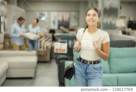 Girls eyes scan room furniture store, searching for perfect item to complete living space Girls eyes scan room furniture store, searching for perfect item to complete living space 138017769