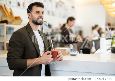 Food court guy visitor sits near table, drink juice in chain cafe shop Food court guy visitor sits near table, drink juice in chain cafe shop 138017870