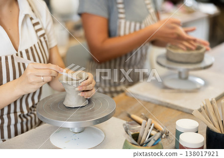 Female hands sculpting clay product close-up 138017921
