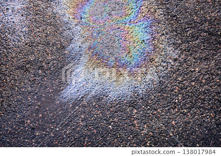 Oil leaking on the road forming a colorful, vibrant rainbow film, showing environmental pollution and urban texture Oil leaking on the road forming a colorful, vibrant rainbow film, showing environmental pollution and urban texture 138017984