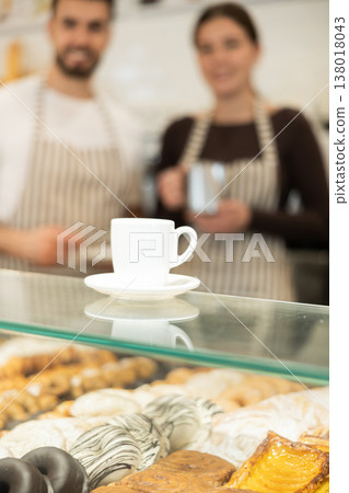 Two cafe employees preparing coffee and delicious pastries 138018043