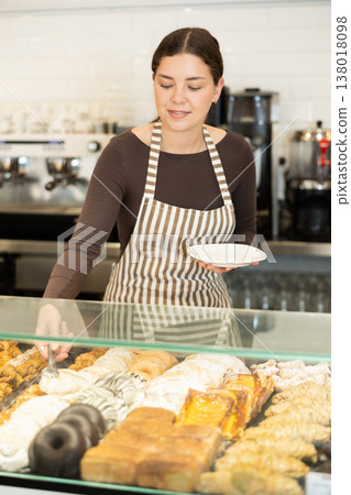 Bakery saleswoman offers to buy delicious pastry Bakery saleswoman offers to buy delicious pastry 138018098