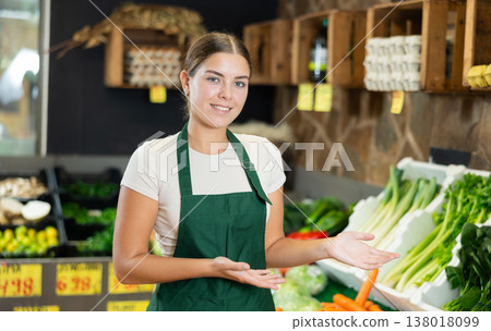 Positive and friendly store girl employee stands with arms crossed on chest and waits for customers 138018099