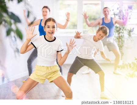 Parents together with their children learn how to dance salsa or boogie-woogie in dance class Parents together with their children learn how to dance salsa or boogie-woogie in dance class 138018121