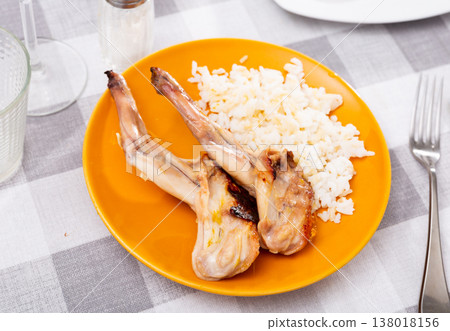 Lunch is served on plate - baked pieces of young rabbit with side dish boiled rice. Lunch is served on plate - baked pieces of young rabbit with side dish boiled rice. 138018156