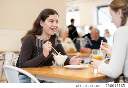 Young woman chatting with teenager in cafe Young woman chatting with teenager in cafe 138018185