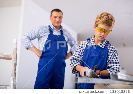 Boy renovating home with father, cutting profile 138018258