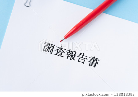 A research report with a red pen on a light blue background. 138018392