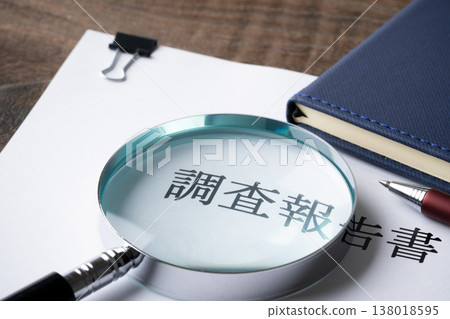 Close-up of the research report, magnifying glass, notebook, and ballpoint pen. Close-up of the research report, magnifying glass, notebook, and ballpoint pen. 138018595
