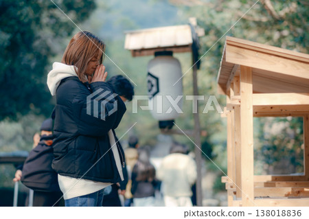 一位二十多歲的女子在神社祈禱的場景。 一位二十多歲的女子在神社祈禱的場景。 138018836