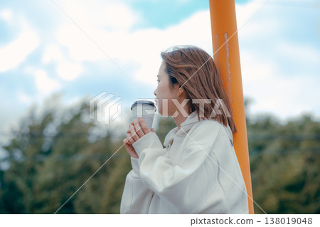 A relaxing scene of a woman in her 20s enjoying coffee at a tourist spot. 138019048