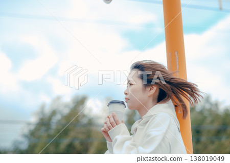 A relaxing scene of a woman in her 20s enjoying coffee at a tourist spot. 138019049