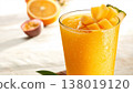 Macro photograph of tropical mixed juice in a clear glass on a bright wooden table. 138019120