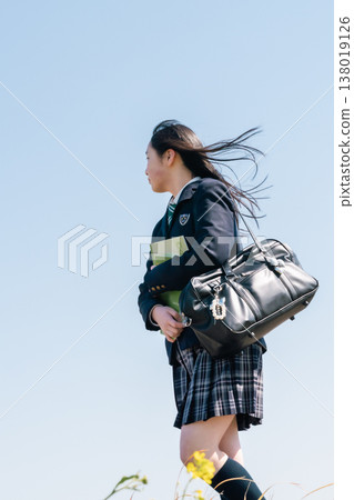 An emotional scene of youth commuting to school. A student in their uniform, carrying a school bag, takes a step forward (face not shown). An emotional scene of youth commuting to school. A student in their uniform, carrying a school bag, takes a step forward (face not shown). 138019126