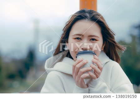 一張遊客肖像照，照片中一位二十多歲的女性正在招呼客人喝咖啡。 138019150
