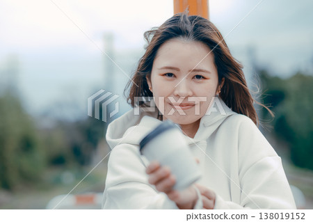 一張遊客肖像照，照片中一位二十多歲的女性正在招呼客人喝咖啡。 138019152
