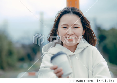 一張遊客肖像照，照片中一位二十多歲的女性正在招呼客人喝咖啡。 138019154