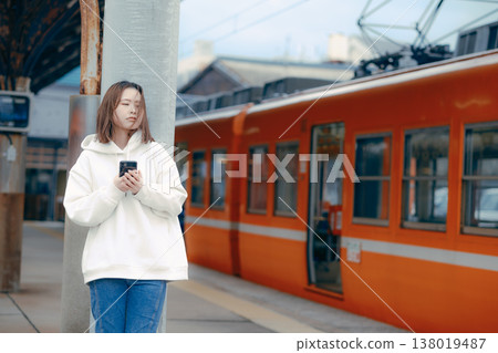 A woman who manipulates a smartphone at the station home A woman who manipulates a smartphone at the station home 138019487