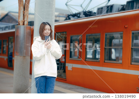 A woman who manipulates a smartphone at the station home A woman who manipulates a smartphone at the station home 138019490