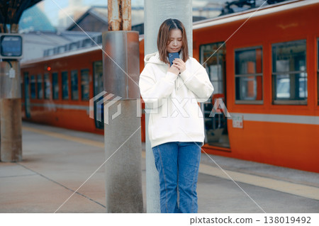 A woman who manipulates a smartphone at the station home 138019492