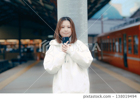 A woman who manipulates a smartphone at the station home A woman who manipulates a smartphone at the station home 138019494