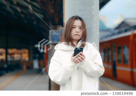 A woman who manipulates a smartphone at the station home A woman who manipulates a smartphone at the station home 138019499
