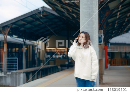 A woman who manipulates a smartphone at the station home A woman who manipulates a smartphone at the station home 138019501