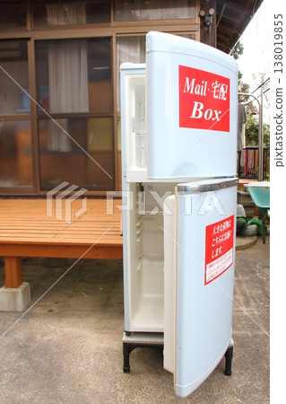 An old, broken refrigerator is being used as a mail/delivery box. An old, broken refrigerator is being used as a mail/delivery box. 138019855