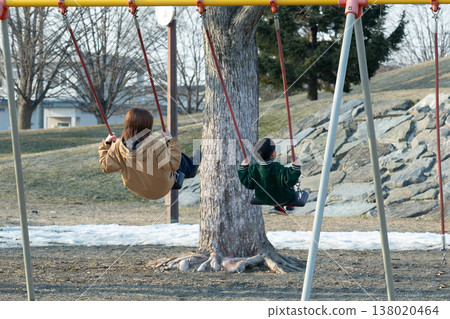Parents playing with a swing in a park Parents playing with a swing in a park 138020464