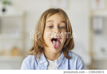 Small kid opening mouth showing tongue to allow check throat during visit in clinic for pediatrician Small kid opening mouth showing tongue to allow check throat during visit in clinic for pediatrician 138020631