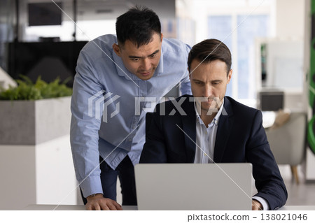 Project coordinator reviewing lapto p screen with subordinate at office workplace Project coordinator reviewing lapto p screen with subordinate at office workplace 138021046