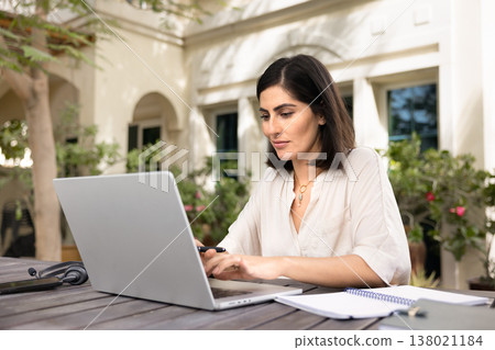 Focused young Hispanic self-employed professional woman typing on laptop 138021184