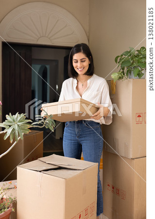 Happy young Hispanic homeowner woman moving into new house 138021185