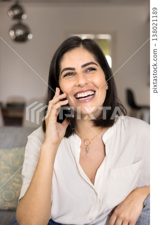 Cheerful positive young Latin phone user woman talking on cell Cheerful positive young Latin phone user woman talking on cell 138021189