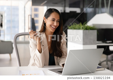 Beautiful woman laughing while using laptop in modern office Beautiful woman laughing while using laptop in modern office 138021194
