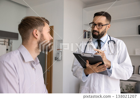 Attentive young male doctor listening to patient complaints collecting anamnesis Attentive young male doctor listening to patient complaints collecting anamnesis 138021207