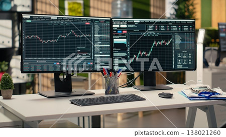 Stock exchange metrics charts displayed on computer screens in investment firm office. Workstation in forex company workspace with live financial data visible on PC monitors Stock exchange metrics charts displayed on computer screens in investment firm office. Workstation in forex company workspace with live financial data visible on PC monitors 138021260