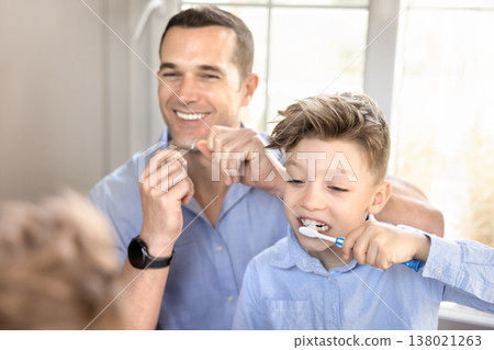 Father using dental floss, child brushing teeth Father using dental floss, child brushing teeth 138021263