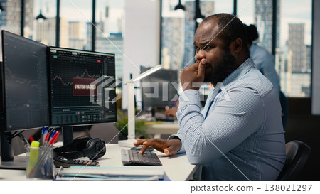 Stressed prop firm employee at work alerted by suspicious hacking alert on trading platform dashboard. Worried african american man in office detects hacking attempt on trading software Stressed prop firm employee at work alerted by suspicious hacking alert on trading platform dashboard. Worried african american man in office detects hacking attempt on trading software 138021297