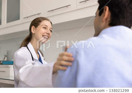 Positive woman nurse or doctor talks warmly with male patient 138021299