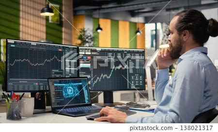 Portfolio manager in office using AI software on laptop to evaluate capital allocation based on economic graphs. Day trader using deep learning on notebook to do research driving growth Portfolio manager in office using AI software on laptop to evaluate capital allocation based on economic graphs. Day trader using deep learning on notebook to do research driving growth 138021317