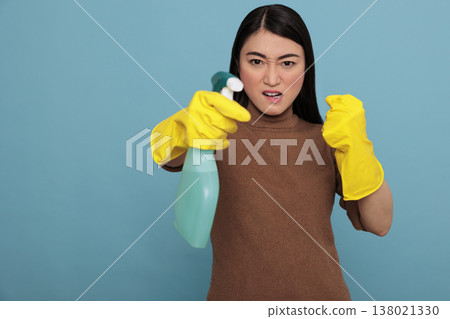 Angry frustrated asian young housewife in rubber gloves and detergent spray standing in a fight pose, Cleaning home concept, Aggressive energetic housekeeper feeling negative 138021330