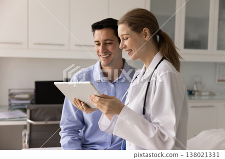 Nurse explains to male patient medical test results on tablet Nurse explains to male patient medical test results on tablet 138021331