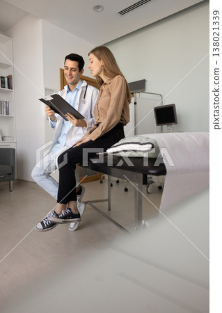 Doctor and woman patient reviewing medical chart 138021339