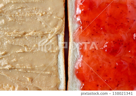 一片麵包上塗抹花生醬和草莓醬,背景是白色,從正上方拍攝。 一片麵包上塗抹花生醬和草莓醬,背景是白色,從正上方拍攝。 138021341