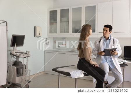 Sonographer filling medical journal while asking about symptoms to patient 138021402