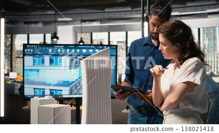 Diverse real estate team creating the layout for a residential area, simulating site preparation with 3D models before the project approval. Modern infrastructure city planning. Diverse real estate team creating the layout for a residential area, simulating site preparation with 3D models before the project approval. Modern infrastructure city planning. 138021418