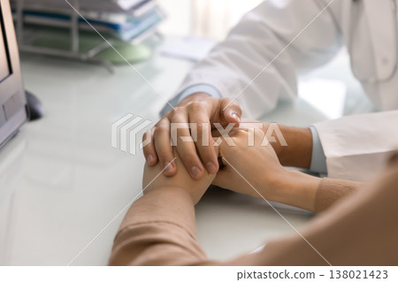 Close up doctor gently holds woman patient hands Close up doctor gently holds woman patient hands 138021423