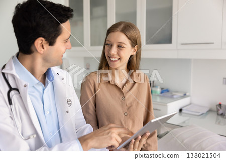 Smiling doctor and patient discuss results on tablet 138021504