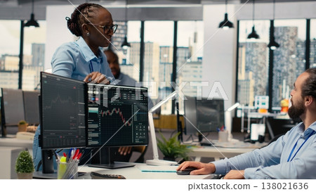 Portfolio manager in wheelchair and coworkers analyze stock market to enhance investment returns. Man with disability and colleagues in inclusive office identify investment opportunities Portfolio manager in wheelchair and coworkers analyze stock market to enhance investment returns. Man with disability and colleagues in inclusive office identify investment opportunities 138021636